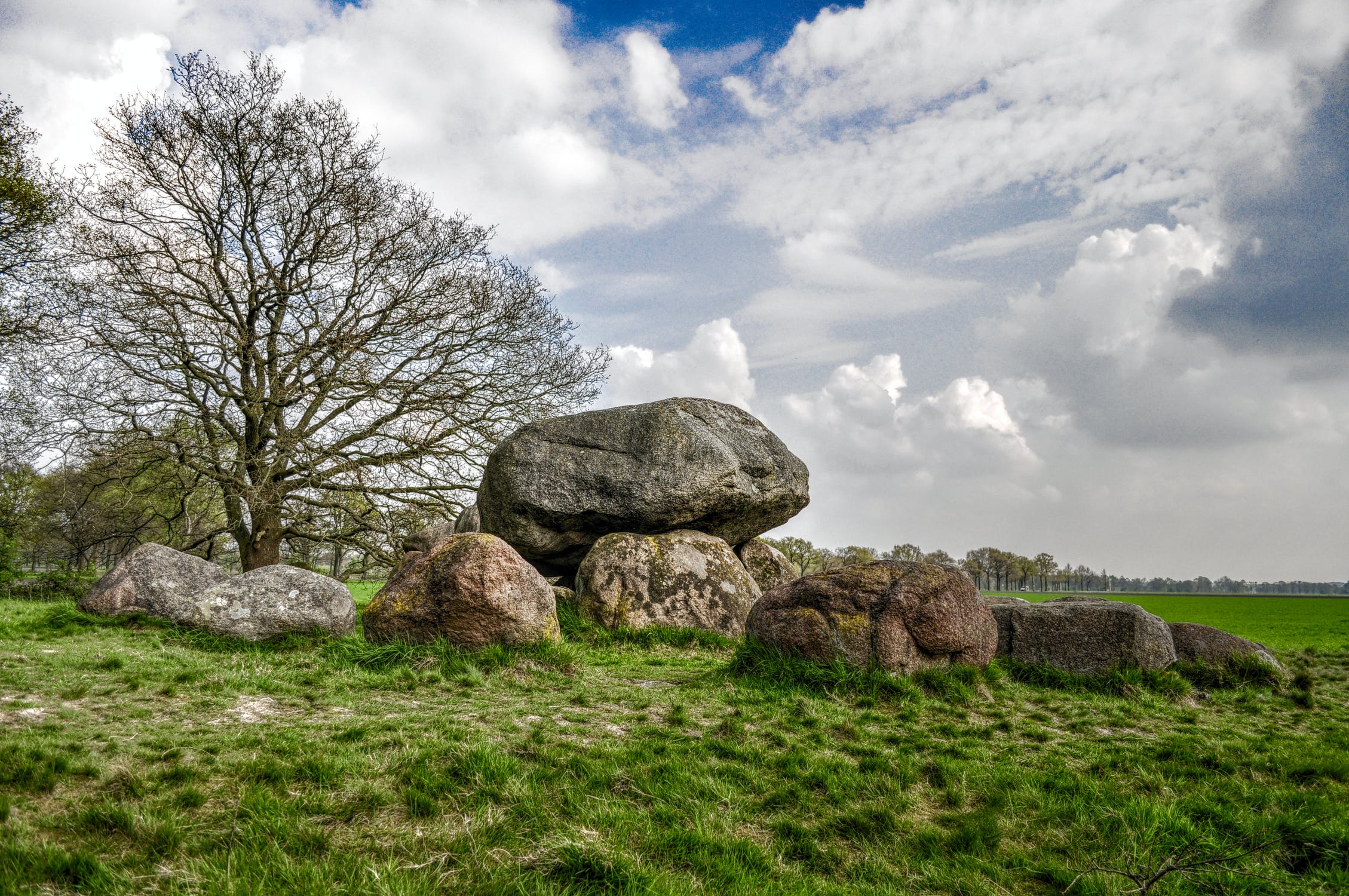 Hunebed bij Doldersum Hunebed in een groen landschap onder een licht bewolkte lucht in Drenthe