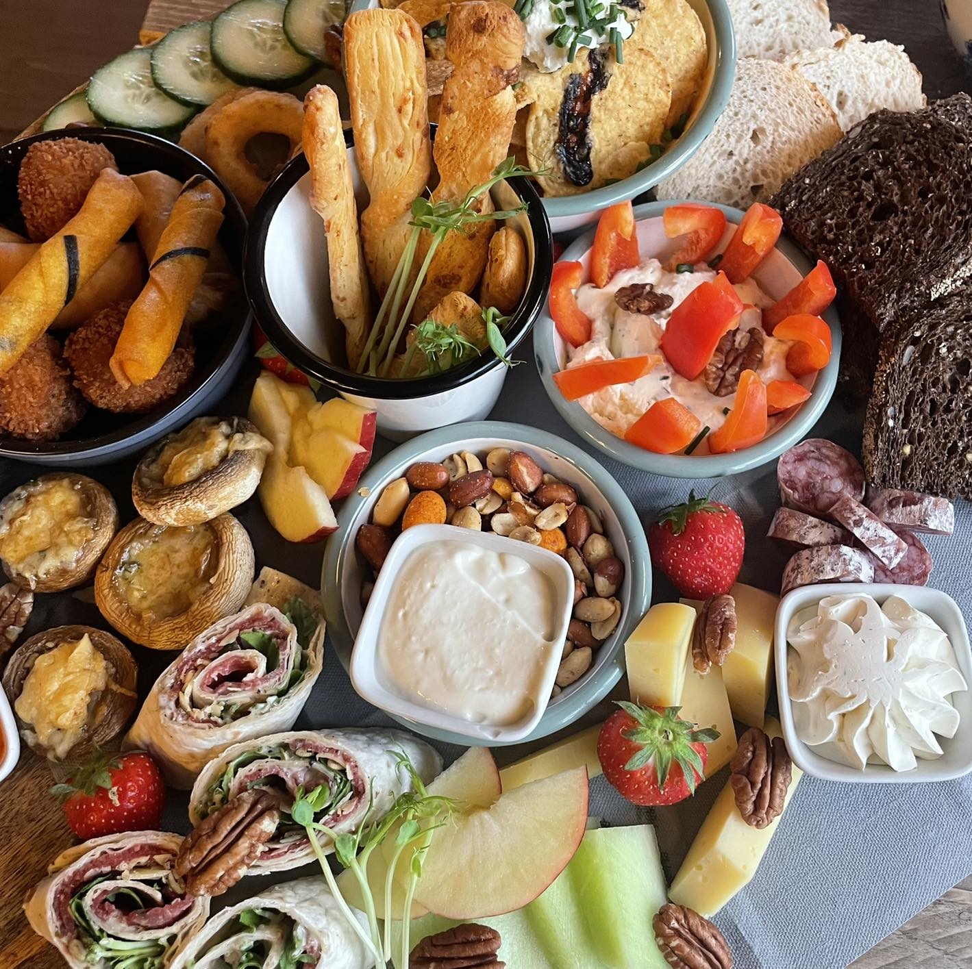Borrelplank met hartige hapjes, dips, noten, brood en fruit bij Grenzeloos